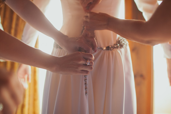 vistiendo a la novia en el día "B". Botones joya y cinturon de pedrería en el vestido de alta costura a medida de Sonia. Beatriz alvaro novias. vestidos de novia. Madrid